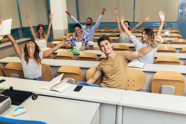 Konsantre öğrenciler üniversite konferans salonunda oturuyor.