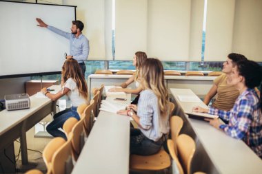 Üniversite atölyesinde erkek konuşmacı sunumu yapıyor..