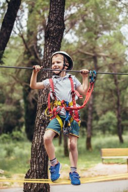 Cesur küçük çocuk macera parkında eğleniyor.
