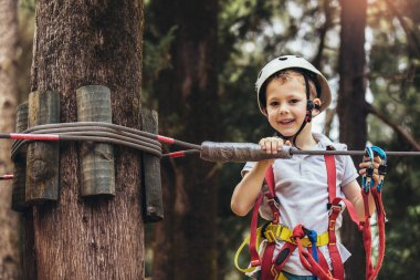 Cesur küçük çocuk macera parkında eğleniyor.