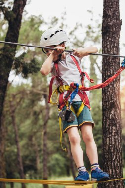 Mutlu çocuk yaz günü tırmanma parkında eğleniyor.