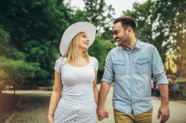 Mutlu genç çift gülüyor ve şehir parkında eğleniyor..