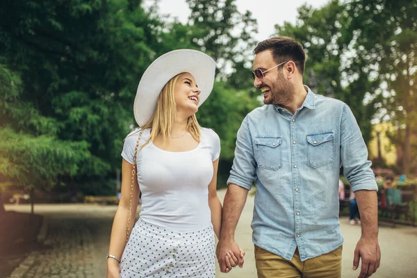 Mutlu genç çift gülüyor ve şehir parkında eğleniyor..