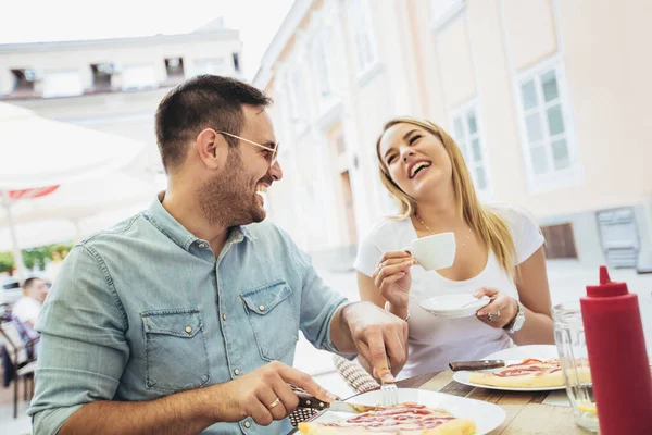 Pizzada eğlenen, birlikte eğlenen genç çiftin fotoğrafı.. 