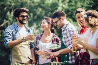 Arkadaşlar doğada bbq yaparak eğleniyorlar.