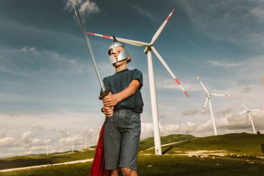 Küçük çocuk oyuncak kılıcı tut Rüzgâr çiftliğinin önünde oynuyor