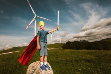 Küçük çocuk oyuncak kılıcı tut Rüzgâr çiftliğinin önünde oynuyor