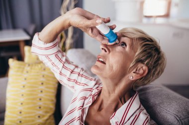 Son sınıf öğrencisi kadın, evde gözlerine damlatan bir ilaç damlatıyor..