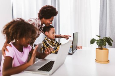Afrika kökenli Amerikalı ilkokul öğrencileri koronavirüs salgınından dolayı bilgisayar kullanıyor ve derslerini internetten takip ediyor.