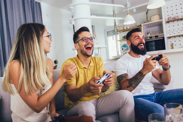 Grupo Amigos Divirtiéndose Sentados Sofá Sala Estar Jugando Videojuegos Casa — Foto de Stock