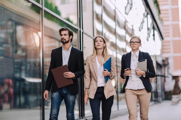 Stock image Three cheerful young business people walking outdoors