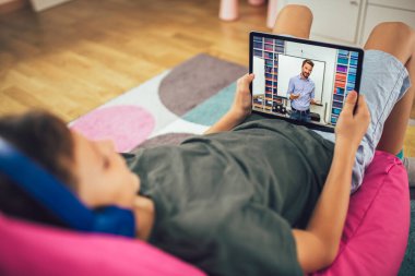 Ödevi için tablet kullanan çocuk portresi. Ev eğitimi konsepti.