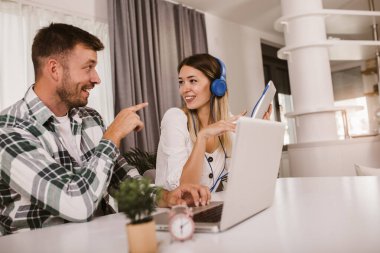 Genç çift evdeki masada oturuyor, internette ayrı ayrı geziniyorlar..