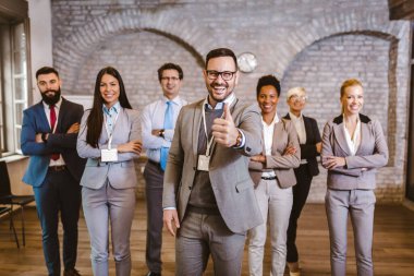 Ofiste elleri çapraz duran kendine güvenen iş adamlarının portresi.