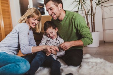 Aile yerde oturuyor ve evde birlikte oynuyorlar. Seçici odak.