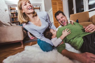 Aile yerde oturuyor ve evde birlikte oynuyorlar. Seçici odak.