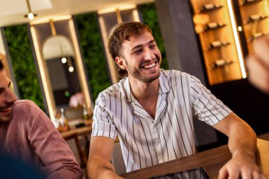 Modern kafede bir grup genç arkadaş tabletten bir şeyler izleyip gündelik sosyal anın tadını çıkarıyorlar..