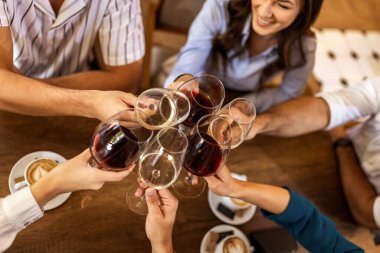 Modern kafede kadeh kaldıran bir grup genç arkadaş.