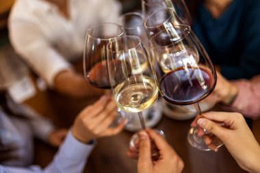 Modern kafede kadeh kaldıran bir grup genç arkadaş.