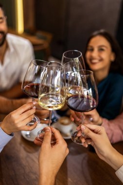 Modern kafede kadeh kaldıran bir grup genç arkadaş.