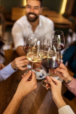 Modern kafede kadeh kaldıran bir grup genç arkadaş.