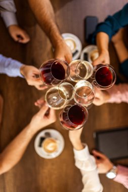 Modern kafede kadeh kaldıran bir grup genç arkadaş.