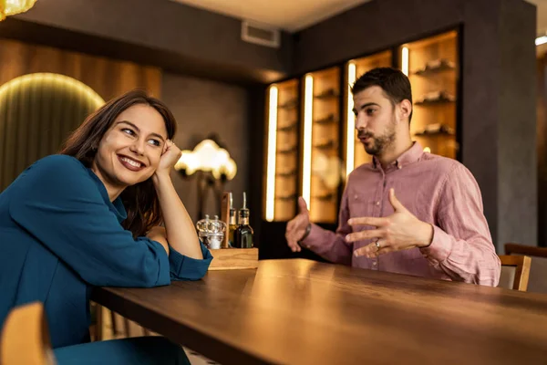 Genç çift modern kafede birlikte oturuyor, sohbet ediyorlar ve gündelik anın tadını çıkarıyorlar..