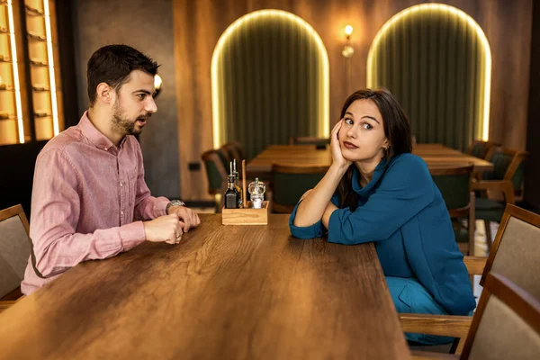 Genç kadın, erkekler modern kafede konuşurken sıkılmış görünüyor.