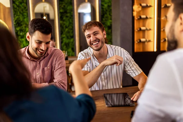 Modern kafede bir grup genç arkadaş tabletten bir şeyler izleyip gündelik sosyal anın tadını çıkarıyorlar..