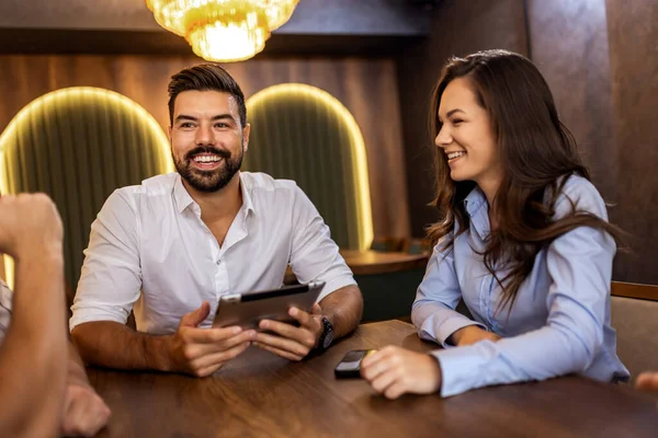Modern kafede bir grup genç arkadaş tabletten bir şeyler izleyip gündelik sosyal anın tadını çıkarıyorlar..