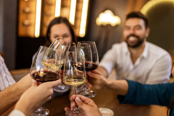 Modern kafede kadeh kaldıran bir grup genç arkadaş.