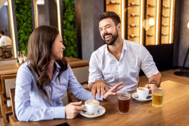 Rahat genç çift, rahat, modern bir kafede kahvelerini yudumluyor, rahat bir hayat tarzı..