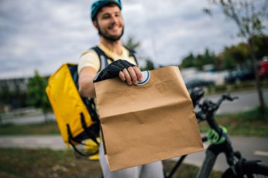Kurye, dışarıdan gelen müşterilere yemek paketi sunuyor. Hızlı dağıtım konsepti, şehir hizmeti, modern şehir yaşam tarzı, kuryelik işi..