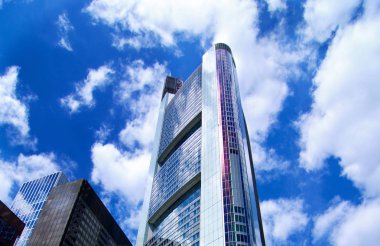 Modern ofis binaları ile gümüş cephe üzerinde mavi bulutlu gökyüzü arka plan açık havada. Alt görünümü kadar