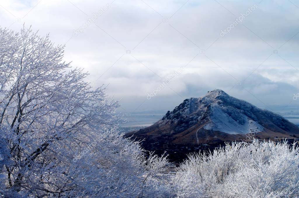 Frosty Snowy Trees, Hills and Mount Beshtau on Cloudy Sky background Outdoors