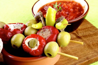 Domates sos, sıcak biber Marine ile hamsi ve yeşil peçete üzerine krem peynir ve kapari closeup ile küçük biber dolması ile lezzetli İspanyolca Pinchos. Ön plan üzerinde odaklanmak