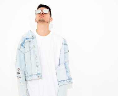 Yakışıklı genç model adam portresi beyaz arka plan üzerinde poz güneş gözlüğü kot elbise giymiş. İzole