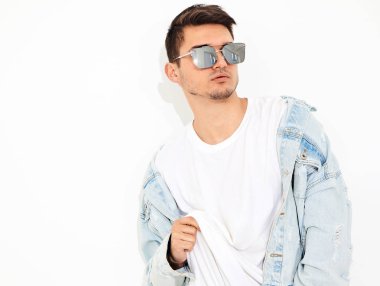 Yakışıklı genç model adam portresi beyaz arka plan üzerinde poz güneş gözlüğü kot elbise giymiş. İzole