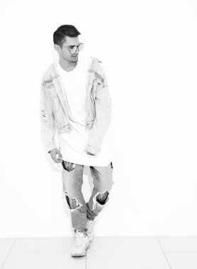 Yakışıklı genç model adam portresi beyaz arka plan üzerinde poz güneş gözlüğü kot elbise giymiş. İzole