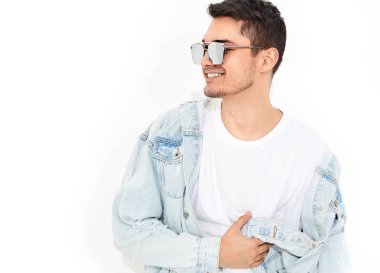 Yakışıklı gülümseyen genç model adam portresi beyaz arka plan üzerinde poz güneş gözlüğü kot elbise giymiş. İzole