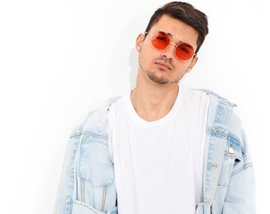 Yakışıklı genç model adam portresi beyaz arka plan üzerinde poz güneş gözlüğü kot elbise giymiş. İzole