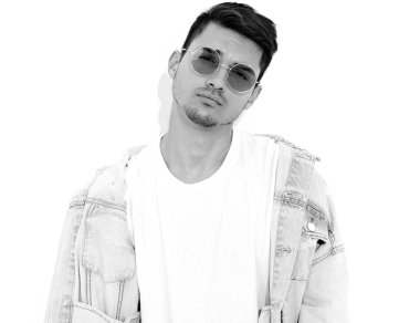 Yakışıklı genç model adam portresi beyaz arka plan üzerinde poz güneş gözlüğü kot elbise giymiş. İzole