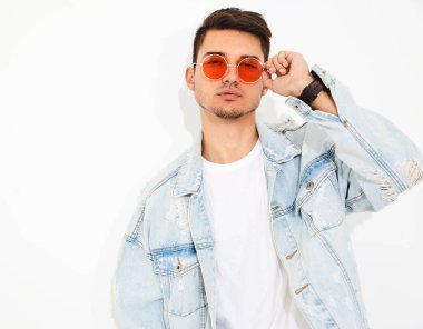 Yakışıklı genç model adam portresi beyaz arka plan üzerinde poz güneş gözlüğü kot elbise giymiş. İzole