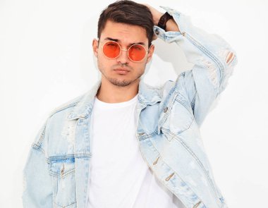 Yakışıklı genç model adam portresi beyaz arka plan üzerinde poz güneş gözlüğü kot elbise giymiş. İzole