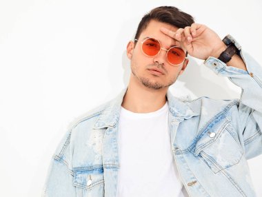 Yakışıklı genç model adam portresi beyaz arka plan üzerinde poz güneş gözlüğü kot elbise giymiş. İzole