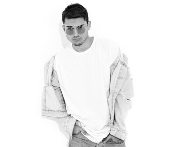 Yakışıklı genç model adam portresi beyaz arka plan üzerinde poz güneş gözlüğü kot elbise giymiş. İzole