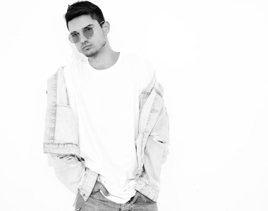 Yakışıklı genç model adam portresi beyaz arka plan üzerinde poz güneş gözlüğü kot elbise giymiş. İzole