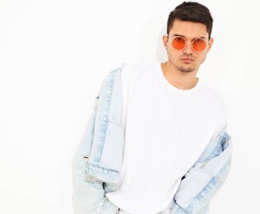 Yakışıklı genç model adam portresi beyaz arka plan üzerinde poz güneş gözlüğü kot elbise giymiş. İzole