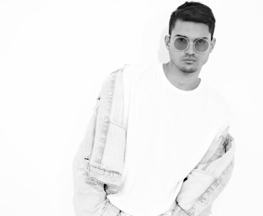 Yakışıklı genç model adam portresi beyaz arka plan üzerinde poz güneş gözlüğü kot elbise giymiş. İzole