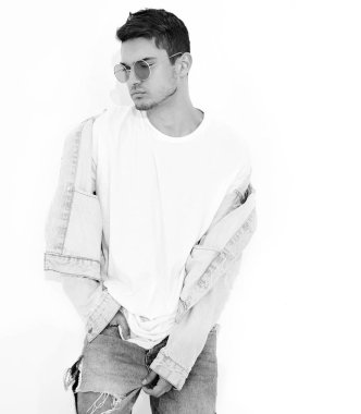 Yakışıklı genç model adam portresi beyaz arka plan üzerinde poz güneş gözlüğü kot elbise giymiş. İzole